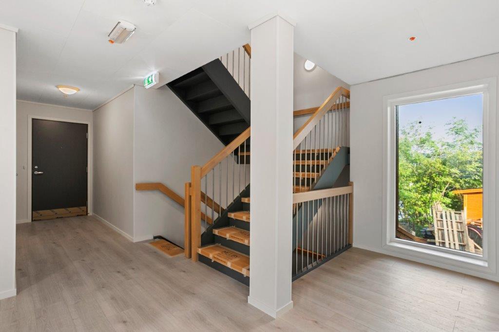 Trappegang med lyse veggar og parkett. Foto.