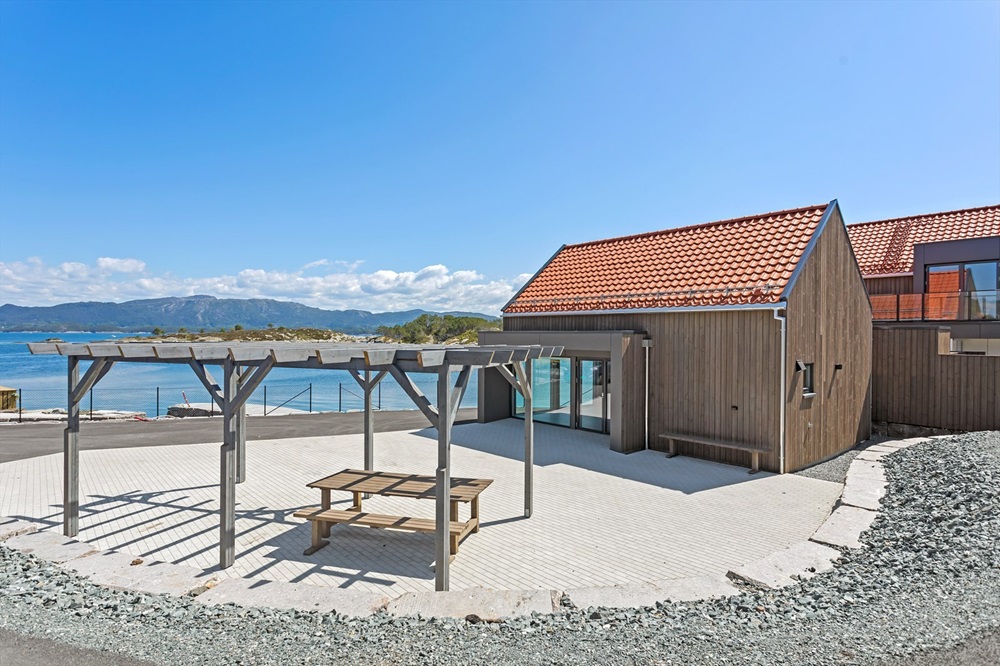 Møteplass med bord og benkar. Foto.