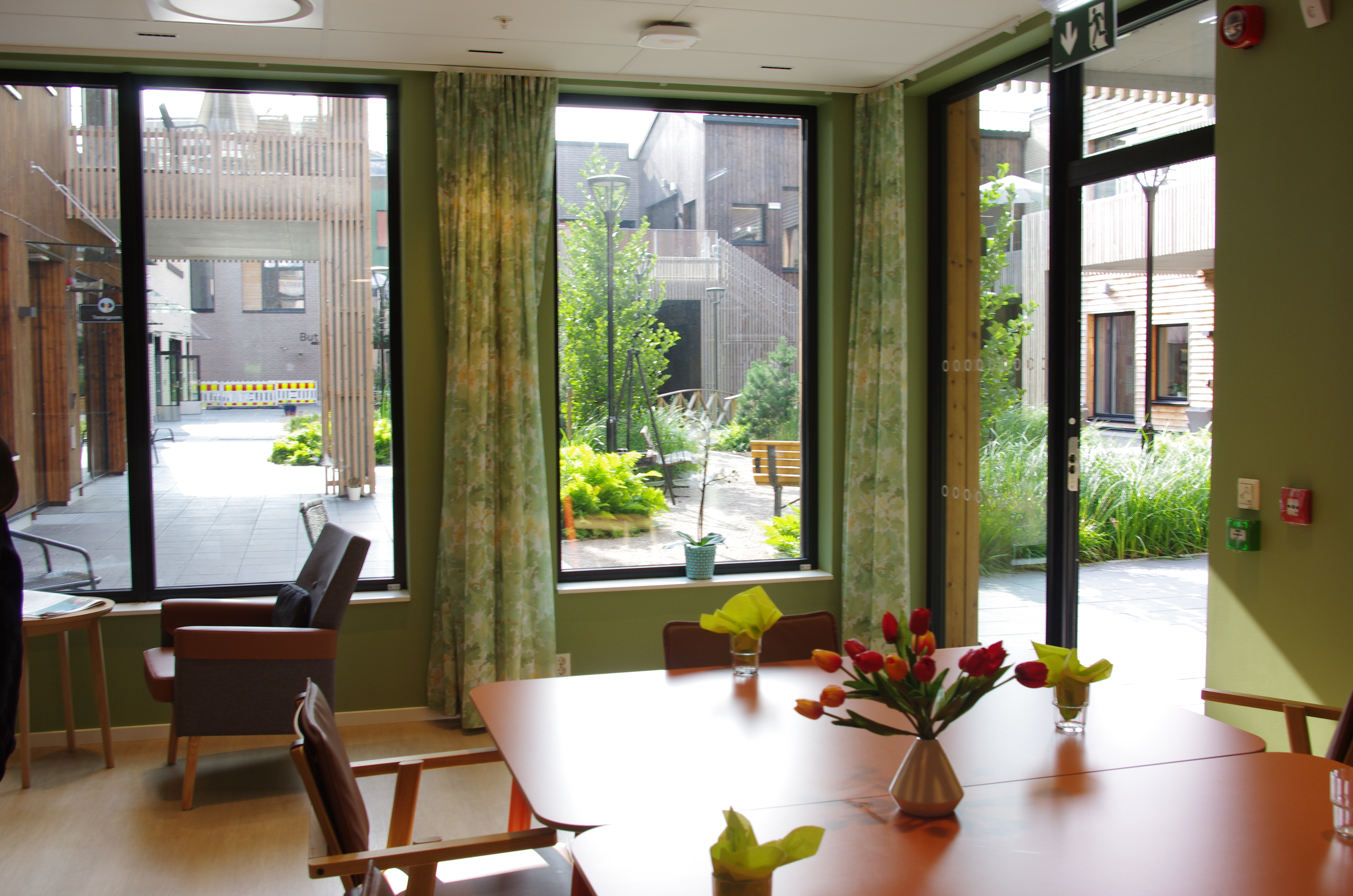 Fellesrom  med utsyn til felles uteplass. Foto.