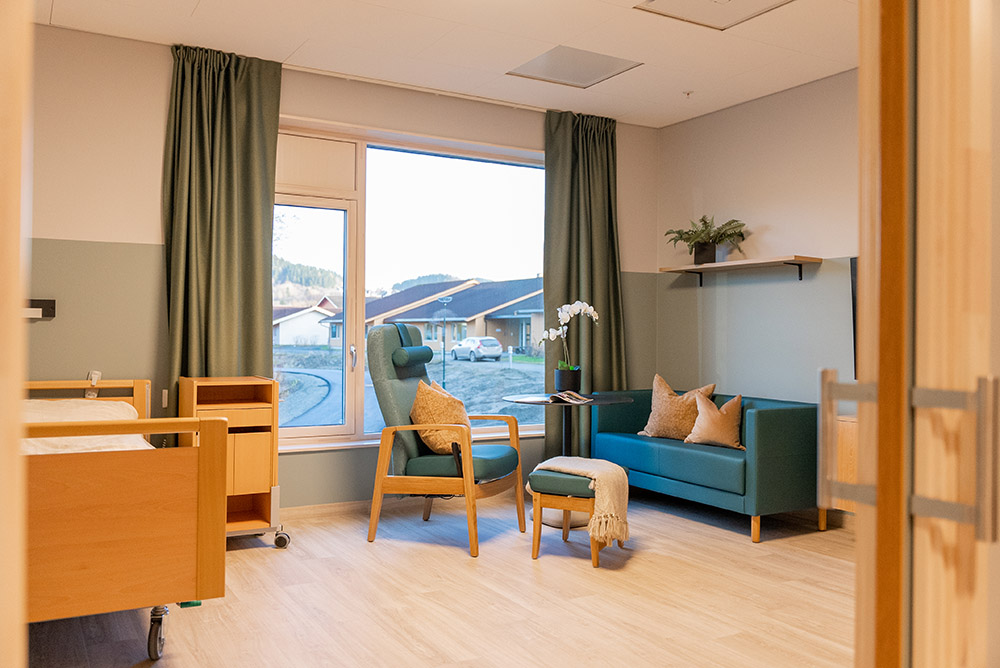 Beboerrom, lyst og romslig, med sofakrok for å ta imot besøk. Foto.