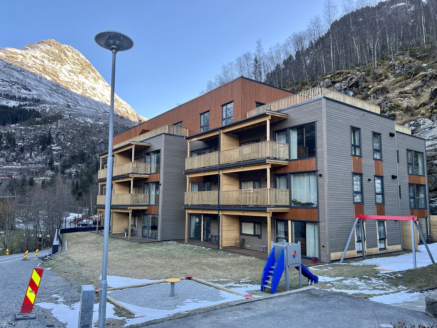 Boligblokk i tre etasjer med balkonger. Foto.