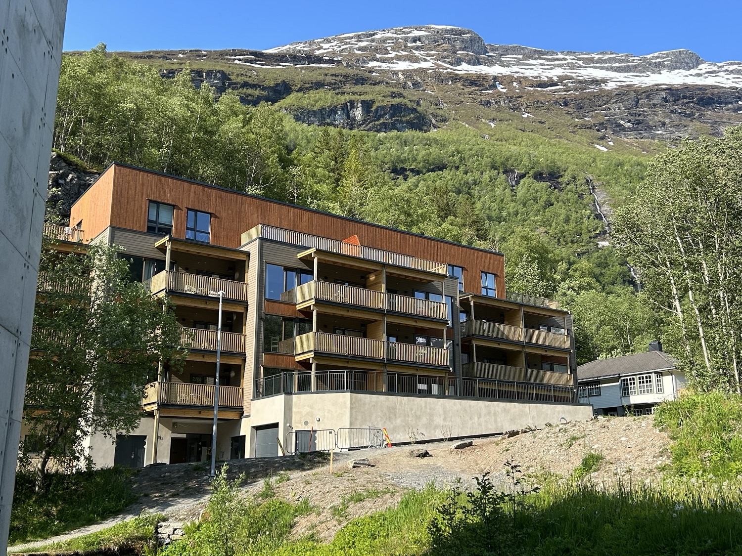 Boligblokk med fjellsiden rett bak. Foto.