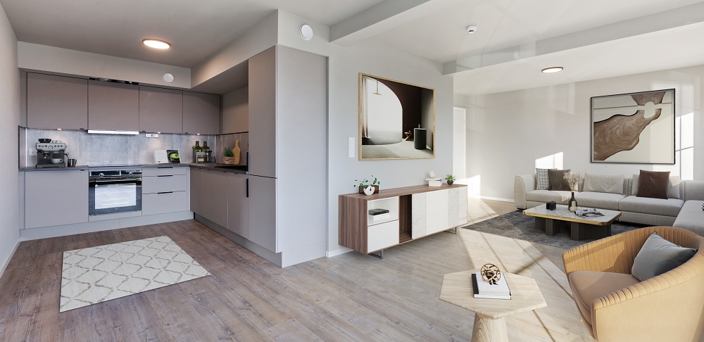 Kjøkken og stue sett fra vinduene. Lysegrå plassbygget kjøkkeninnredning i en romslig u-formet del av rommet. Over- og underskap, integrerte hvitevarer. Foto. 