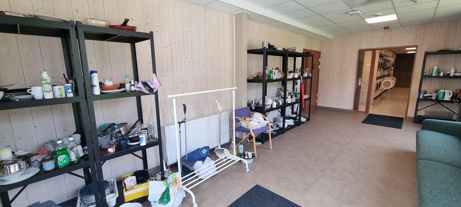 Gjenbruksrom med ting og tang til overs som studentene kan plukke. Fellesvaskeri i naborommet innenfor. Foto. 