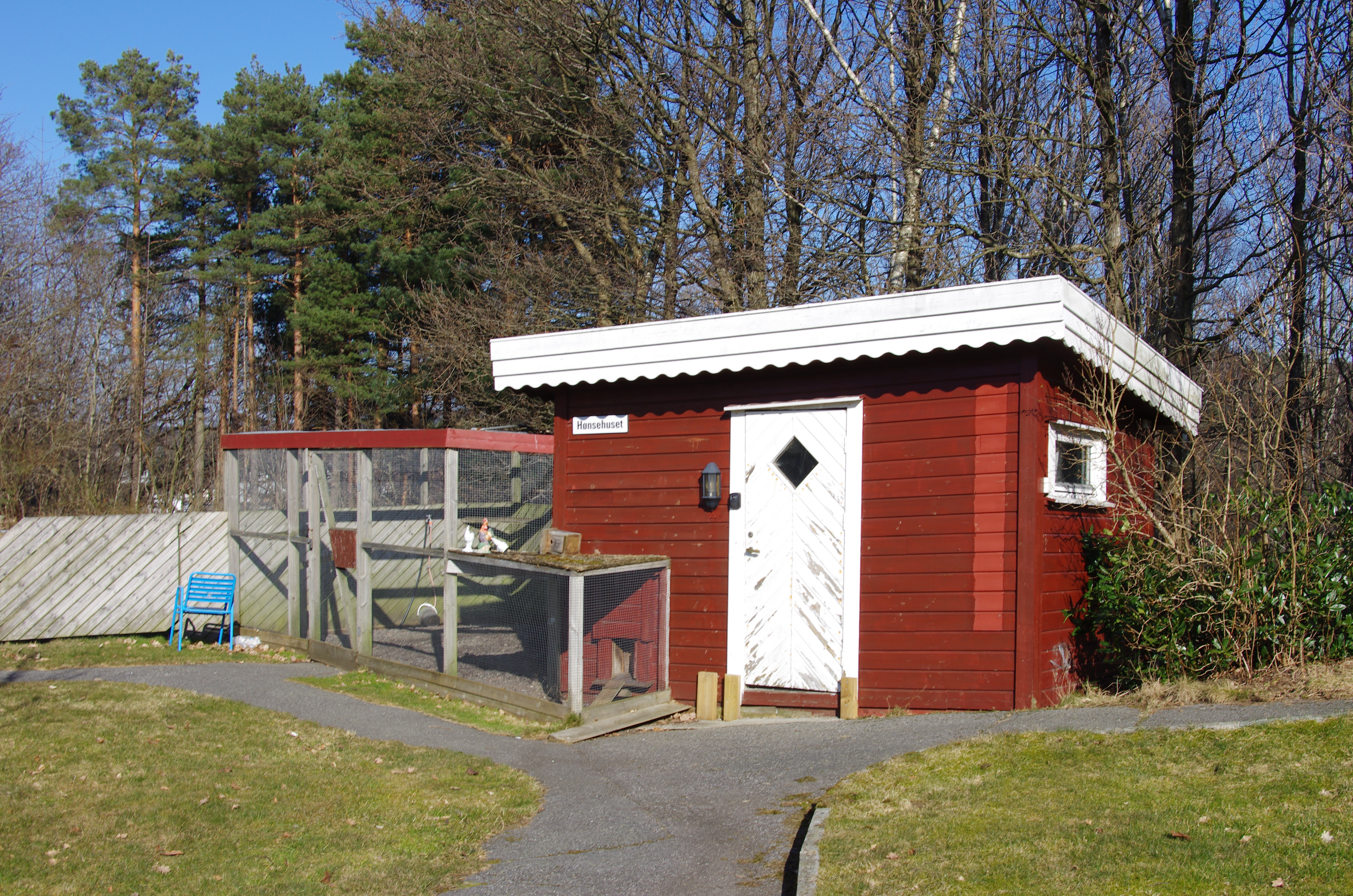 Lite rødt uthus for dyrehold. Foto.