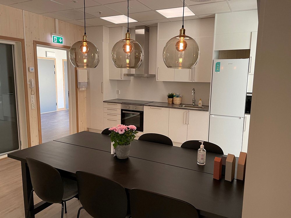 Felles oppholdsrom med spisebord og kjøkken. Foto.