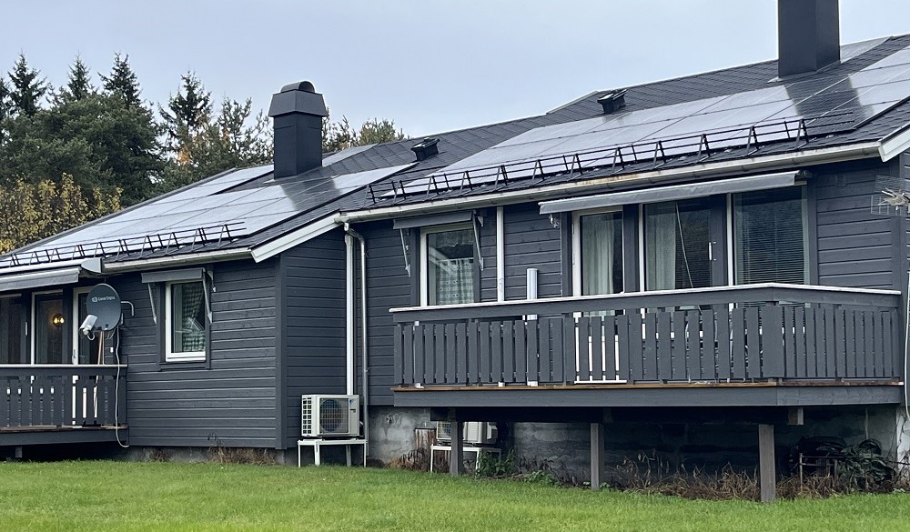 Oppgradert utleiebolig. To gråmalte rekkehus med terrasse og grønn plen. Solceller på taket.