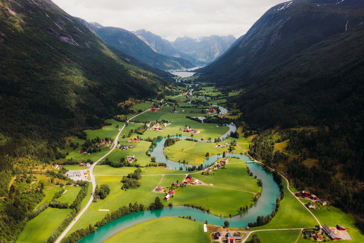 Flyfoto av dalføre med elv og spredt bebyggelse